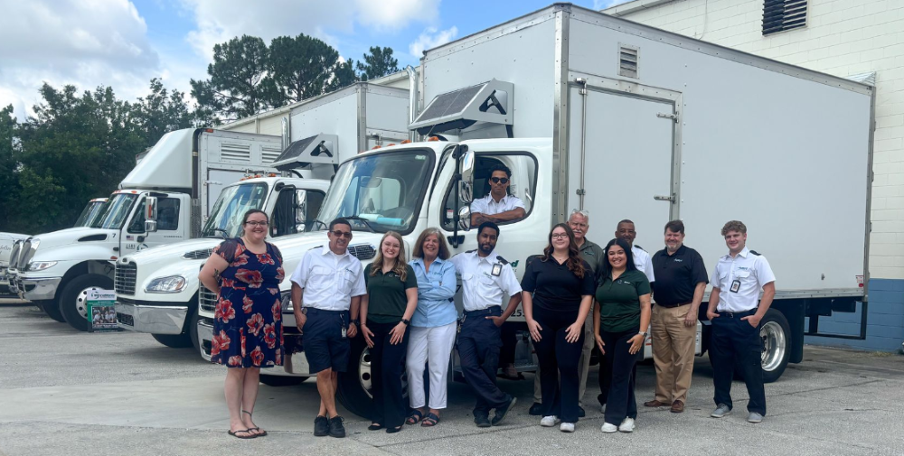 The UltraShred team standing in front of a fleet of trucks